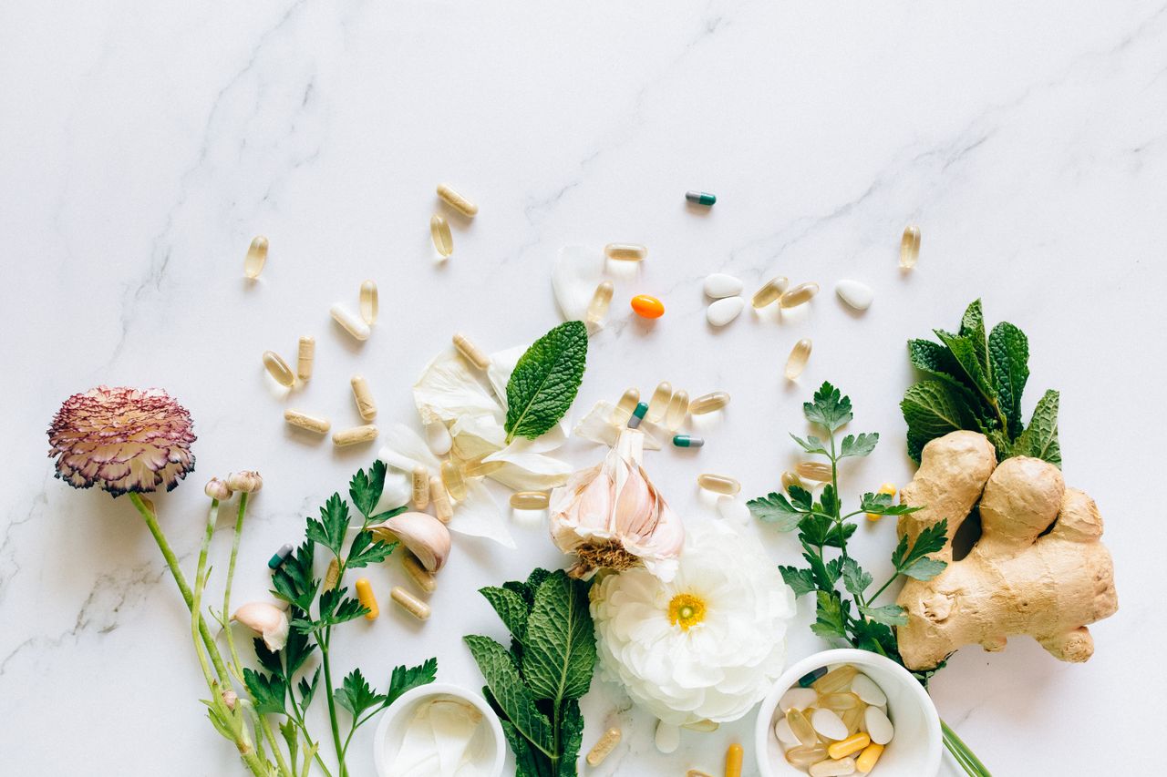 Home Natural herbs and pills arranged on a marble surface for a holistic healthcare theme.